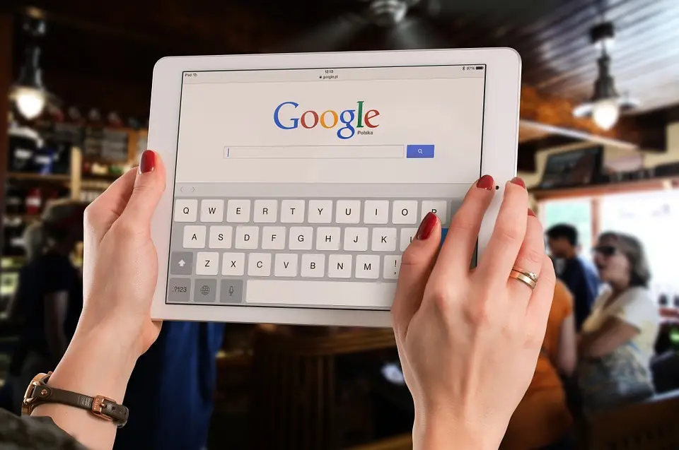 tablet con sito google visualizzato a schermo tra le mani di una donna